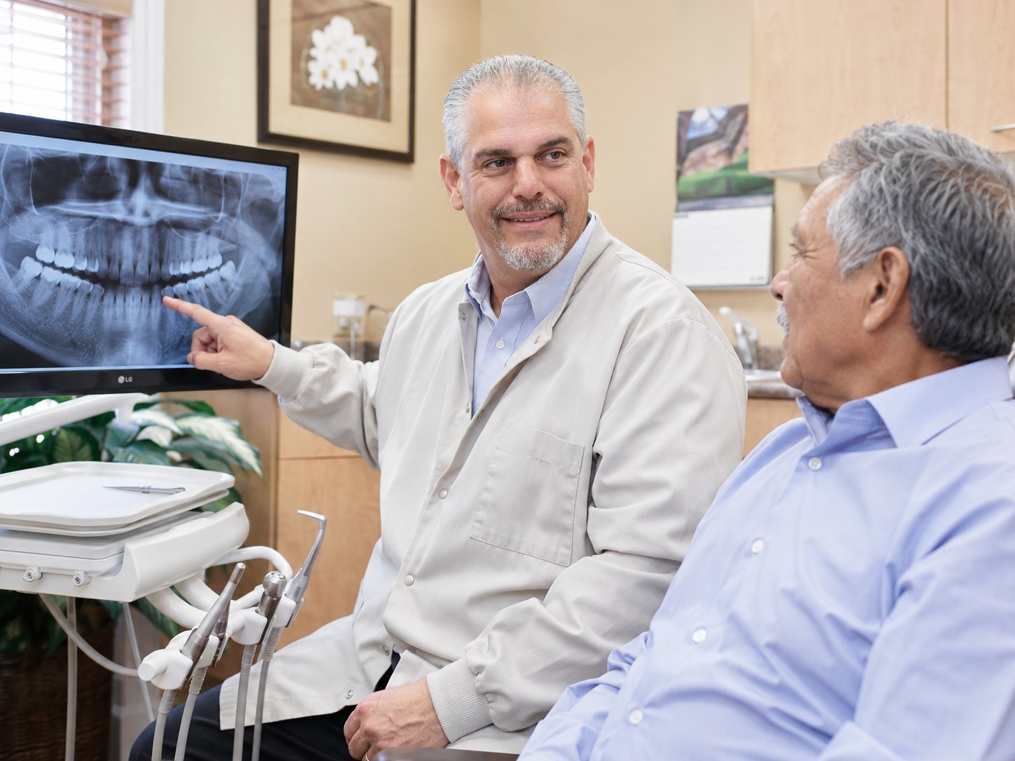 Dr. George Parlitsis reviewing a panoramic dental X-ray with a patient at Carmel Dental Associates